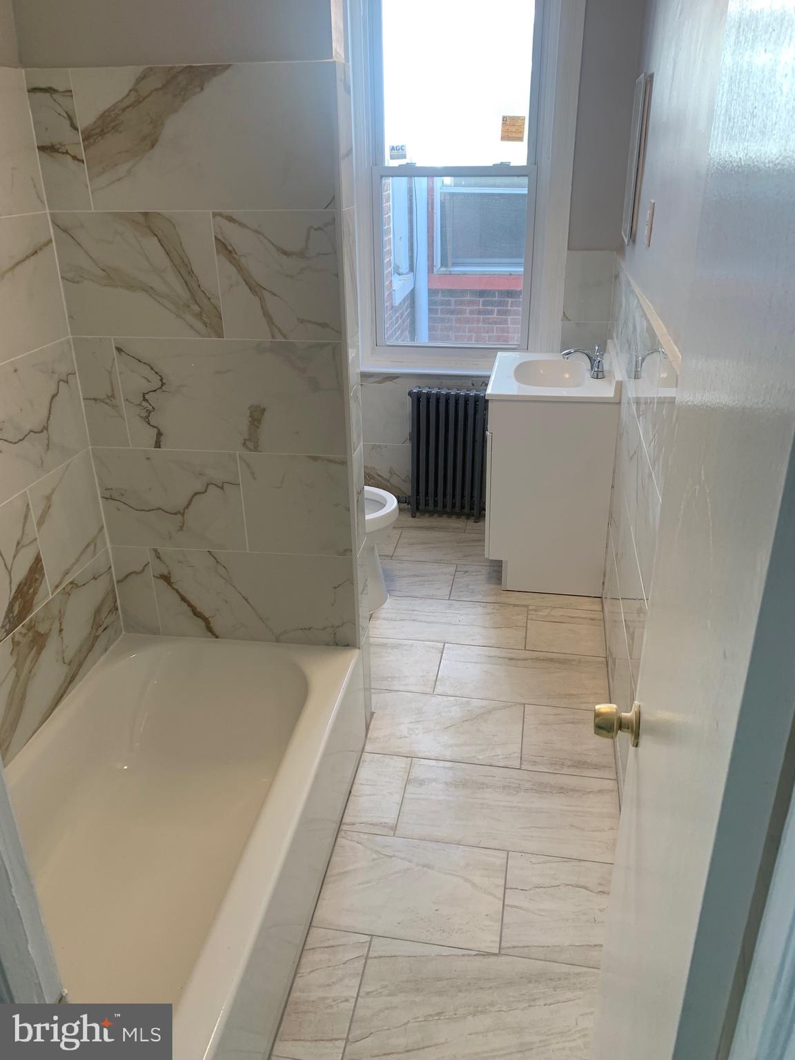 2387 Orthodox Street Philadelphia, PA 19137 - Photo 6 of 12 a bath tub sitting in a bathroom next to a window
