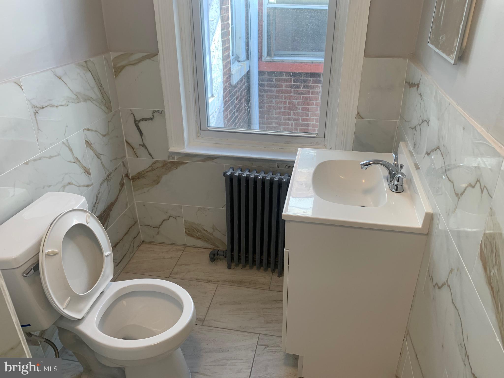 2387 Orthodox Street Philadelphia, PA 19137 - Photo 7 of 12 a bathroom with a sink a toilet and a window