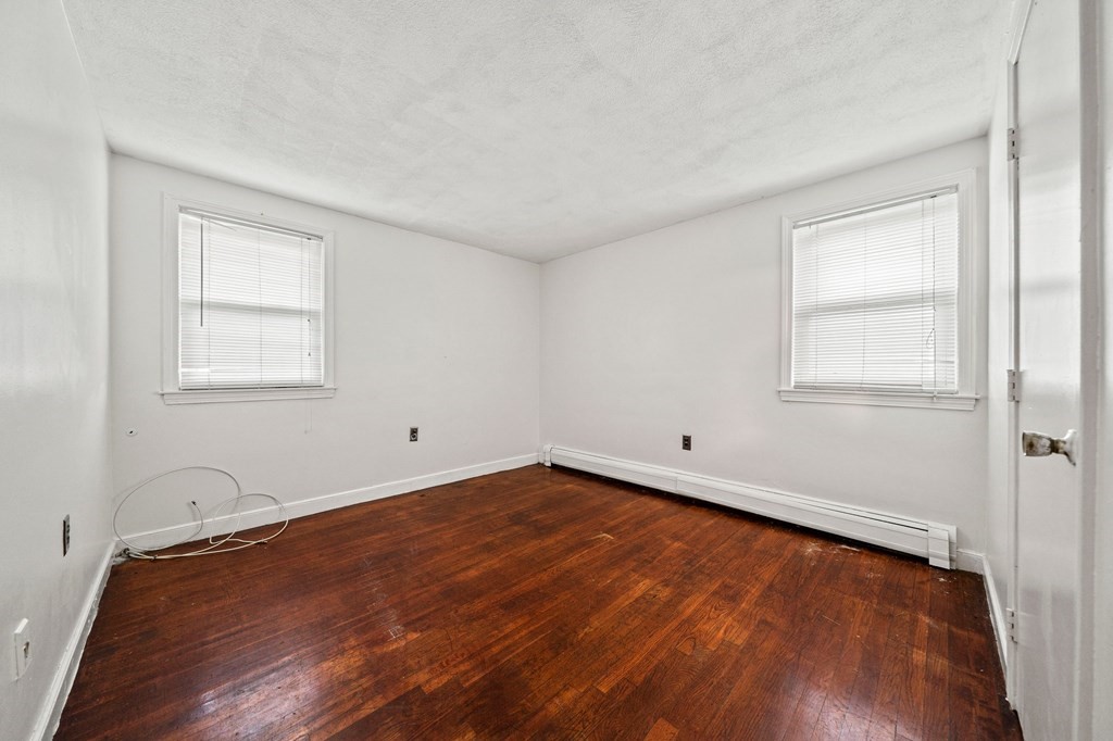 65 Wyvern Street Boston, MA 02131 - Photo 11 of 26 a view of an empty room with wooden floor and a window