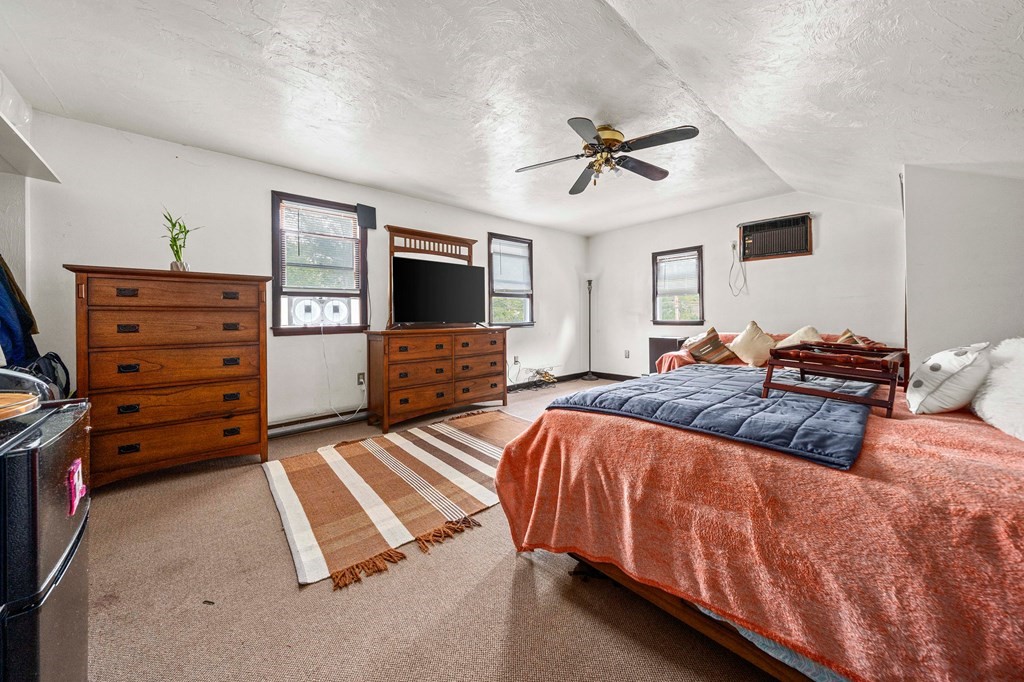 65 Wyvern Street Boston, MA 02131 - Photo 15 of 26 a bedroom with a bed and flat screen tv