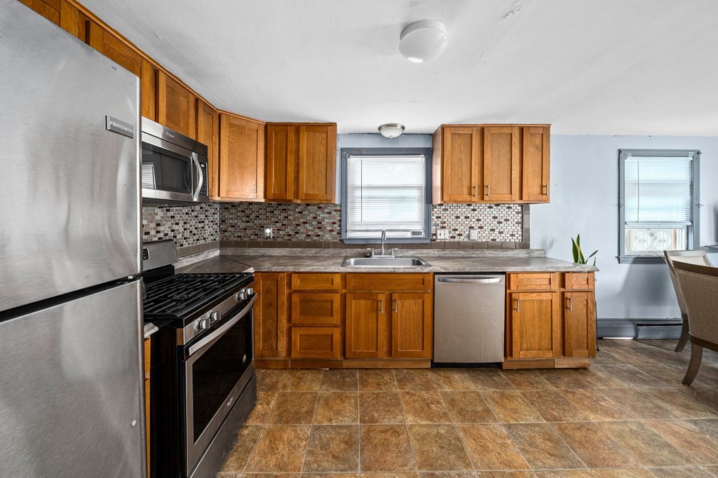 65 Wyvern Street Boston, MA 02131 - Photo 6 of 26 a kitchen with granite countertop a stove a sink and a refrigerator