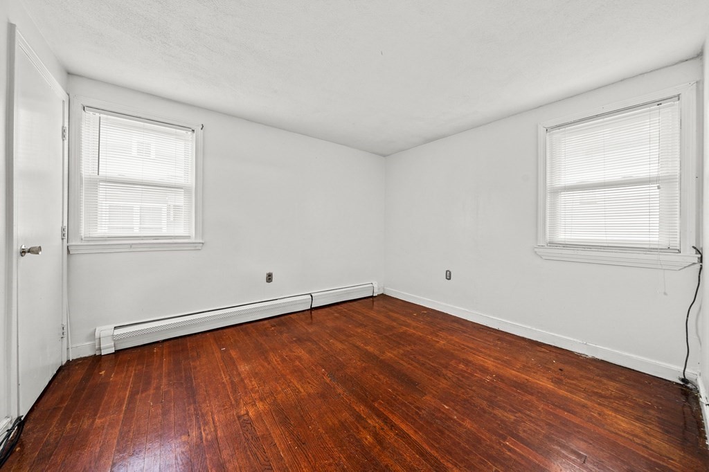 65 Wyvern Street Boston, MA 02131 - Photo 10 of 26 an empty room with wooden floor and windows