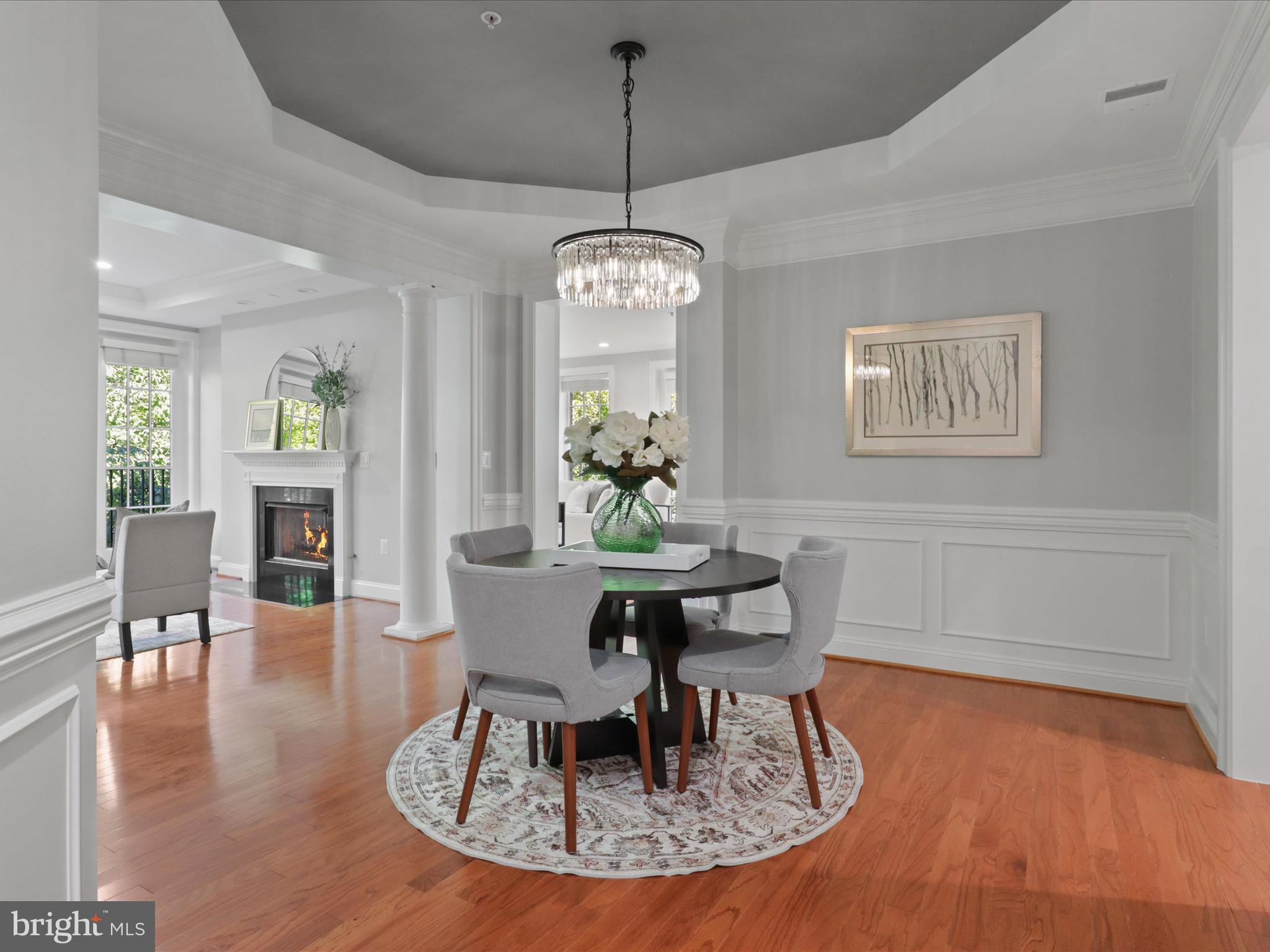 1781 Chain Bridge Road, Unit 303 McLean, VA 22102 - Photo 19 of 56 a dining room with wooden floor a chandelier a wooden table and chairs