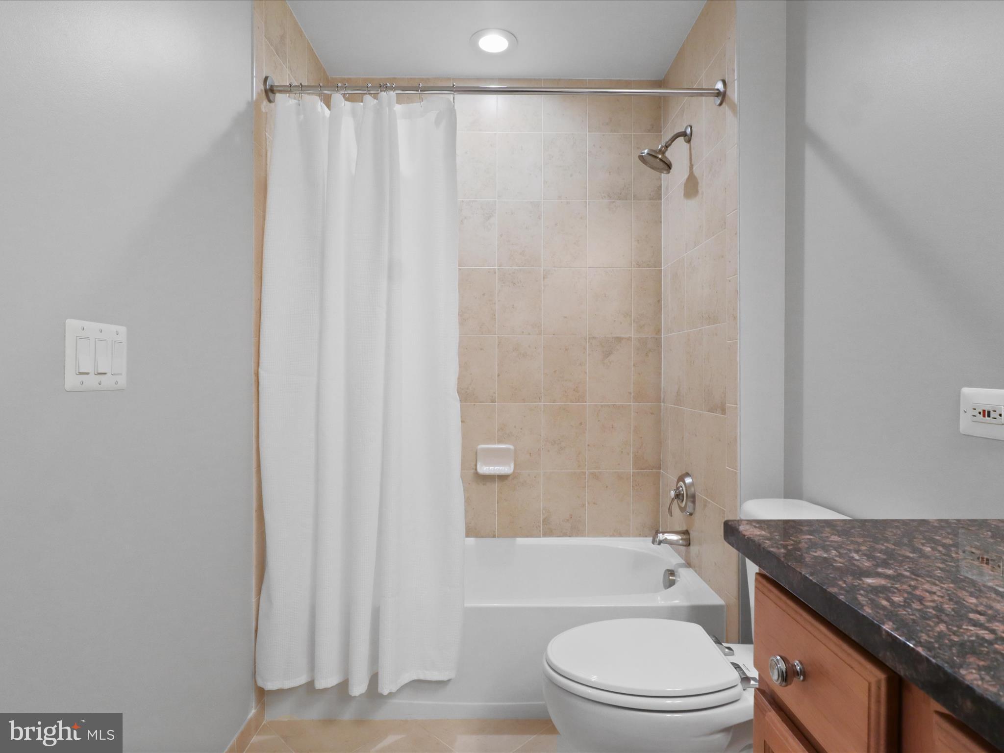 1781 Chain Bridge Road, Unit 303 McLean, VA 22102 - Photo 29 of 56 a bathroom with a granite countertop toilet a sink and a shower