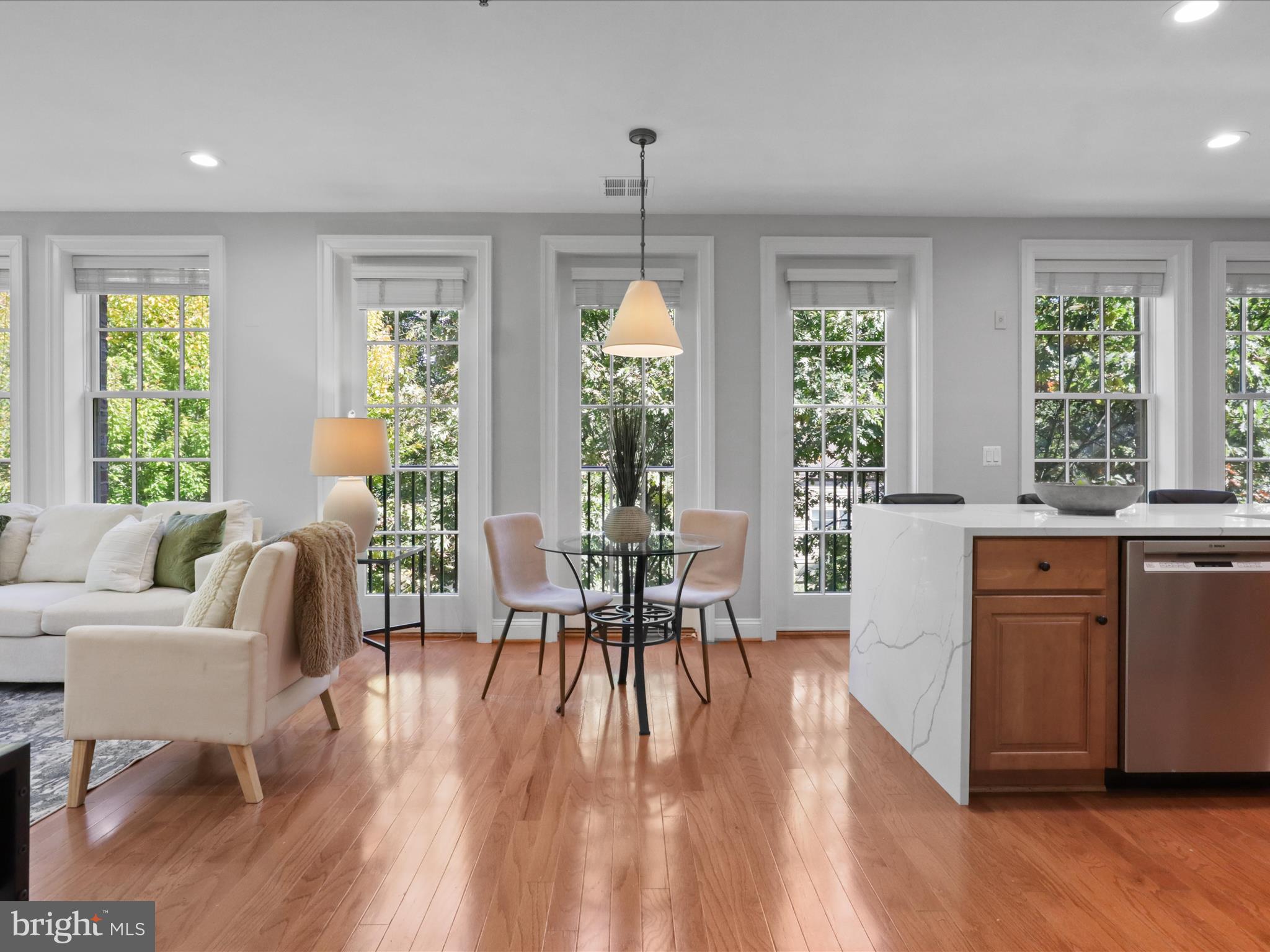1781 Chain Bridge Road, Unit 303 McLean, VA 22102 - Photo 30 of 56 a dining room with wooden floor a chandelier a wooden table and chairs