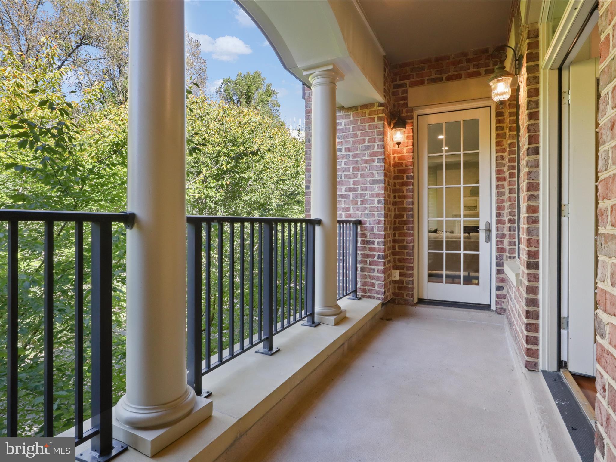 1781 Chain Bridge Road, Unit 303 McLean, VA 22102 - Photo 38 of 56 a view of a balcony with blue floor to ceiling windows and yard