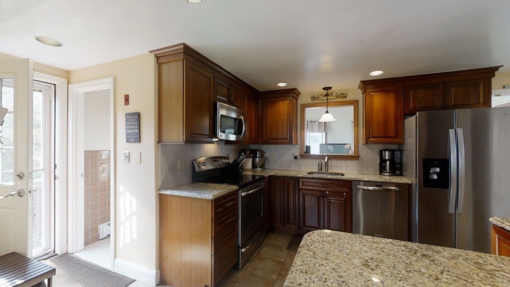 17 Oakcrest Road Needham, MA 02492 - Photo 8 of 31 a kitchen with a sink a refrigerator a stove top oven and granite countertops