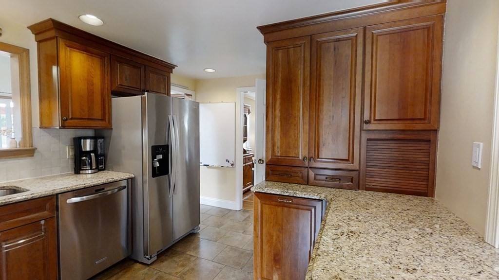 17 Oakcrest Road Needham, MA 02492 - Photo 10 of 31 a kitchen with stainless steel appliances granite countertop wooden cabinets a sink and a refrigerator