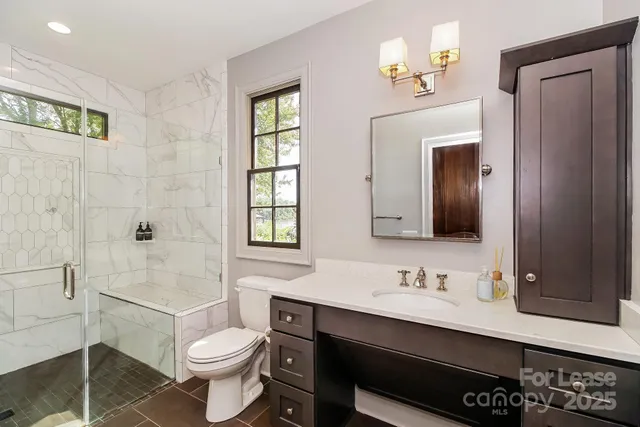 a bathroom with a sink toilet a mirror and shower