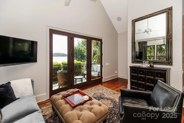 a living room with furniture a flat screen tv and a floor to ceiling window