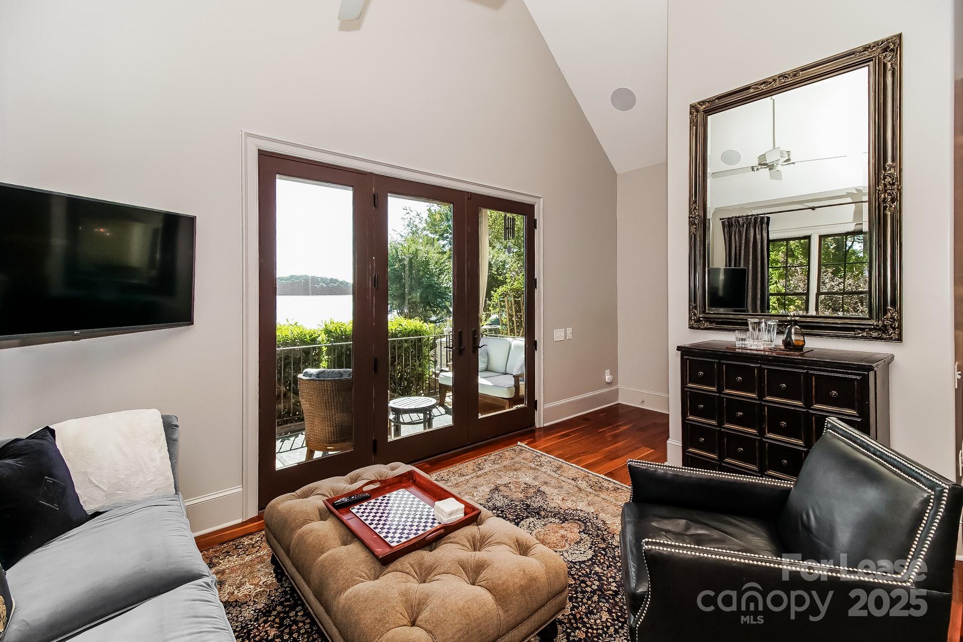 17120 Belle Isle Drive, Unit A Cornelius, NC 28031 - Photo 6 of 16 a living room with furniture a flat screen tv and a floor to ceiling window