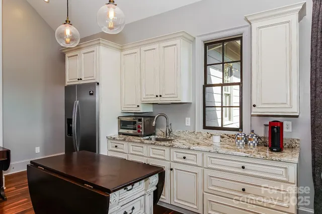 a kitchen with granite countertop a stove sink and cabinets