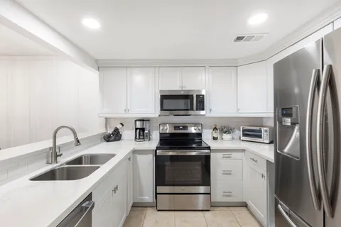 a kitchen with stainless steel appliances granite countertop a refrigerator sink and stove