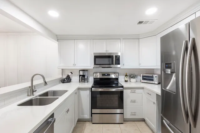 a kitchen with stainless steel appliances granite countertop a refrigerator sink and stove
