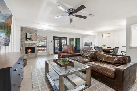 a living room with furniture a fireplace and a chandelier