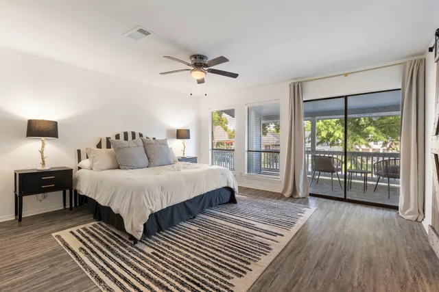 a spacious bedroom with a bed and wooden floor