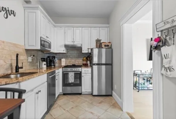 a kitchen with stainless steel appliances granite countertop a refrigerator sink and cabinets