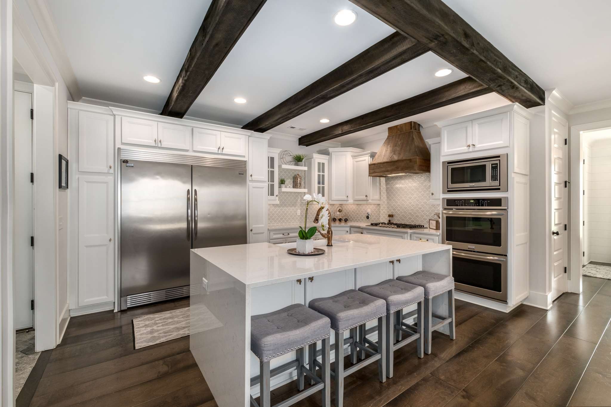 107 Vanner Road Mount Juliet, TN 37122 - Photo 9 of 54 a kitchen with stainless steel appliances kitchen island granite countertop a refrigerator a stove a microwave oven a dining table and chairs with wooden floor