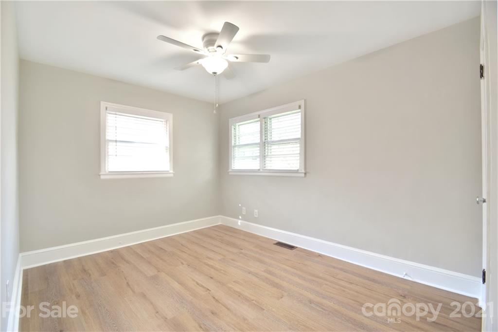 1727 Merry Oaks Road Charlotte, NC 28205 - Photo 13 of 20 an empty room with wooden floor and windows