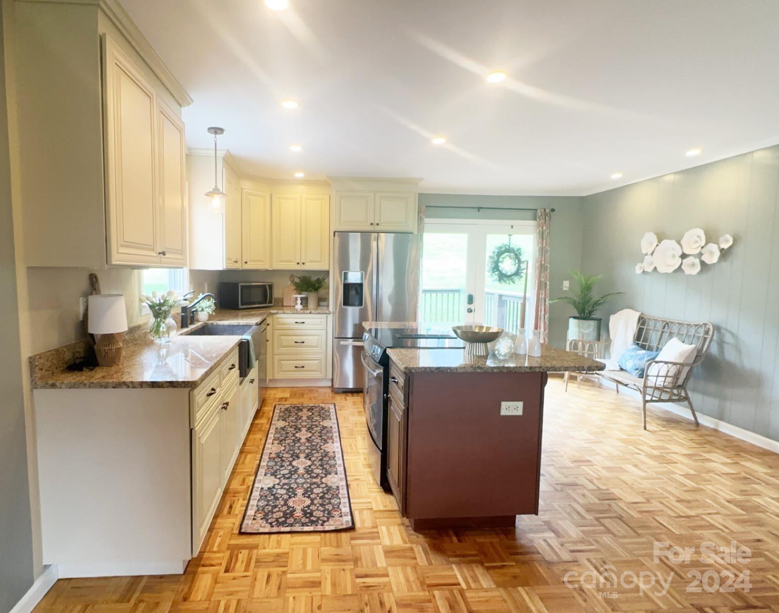 52 Sugar Loaf Road Sylva, NC 28779 - Photo 9 of 45 a kitchen with stainless steel appliances granite countertop a stove top oven a sink dishwasher and cabinets with wooden floor