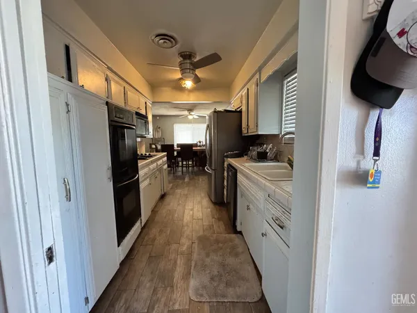 a kitchen with stainless steel appliances a sink a stove top oven a chimney and a refrigerator