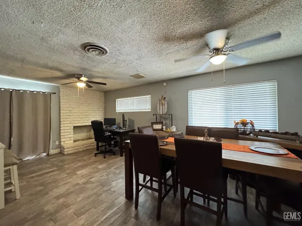 a dining hall with stainless steel appliances granite countertop a refrigerator and a stove top oven