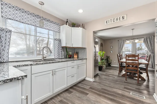 a kitchen with granite countertop a sink cabinets and wooden floor