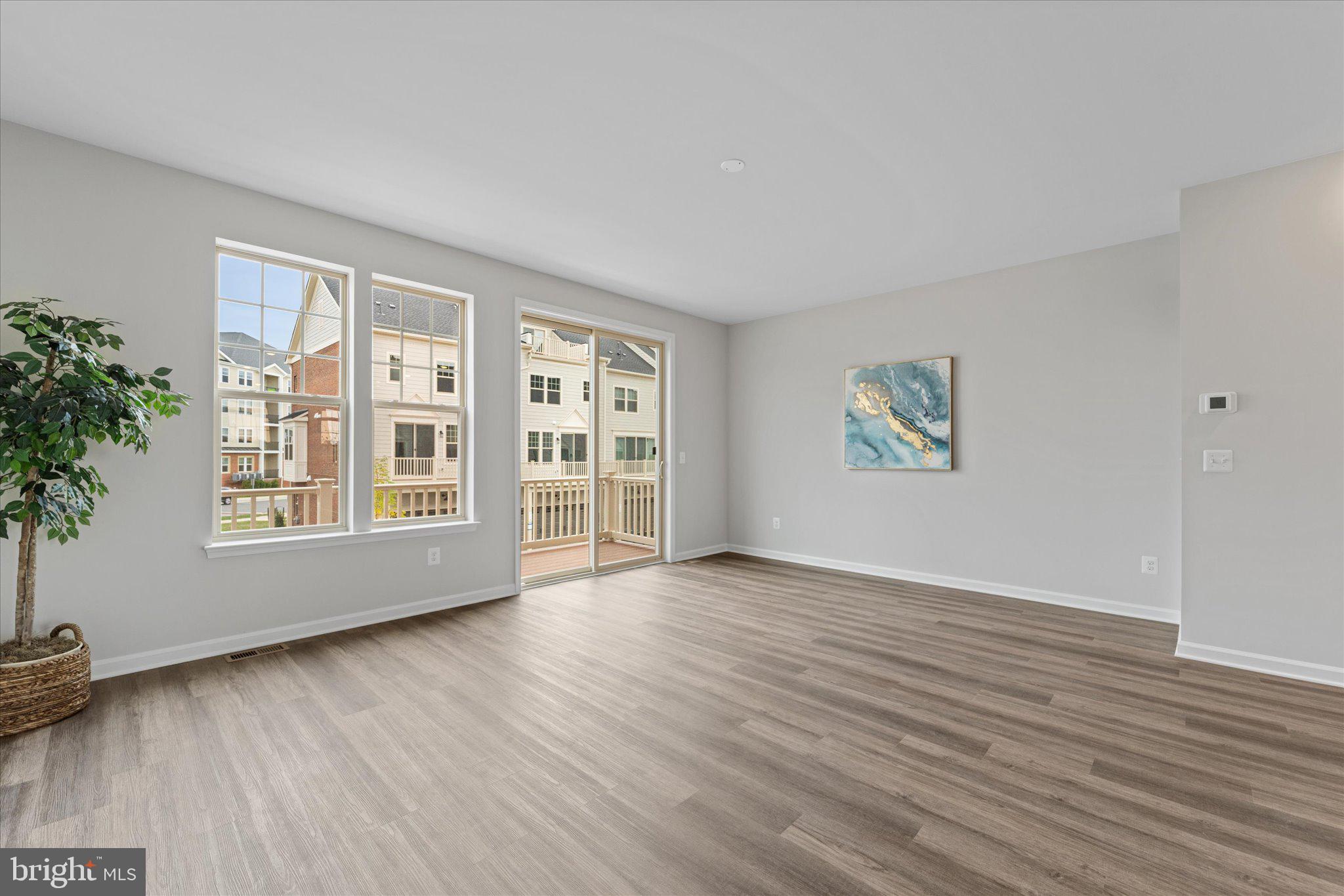 705 Sawback Square Northeast Leesburg, VA 20176 - Photo 9 of 38 a view of an empty room with a window and wooden floor