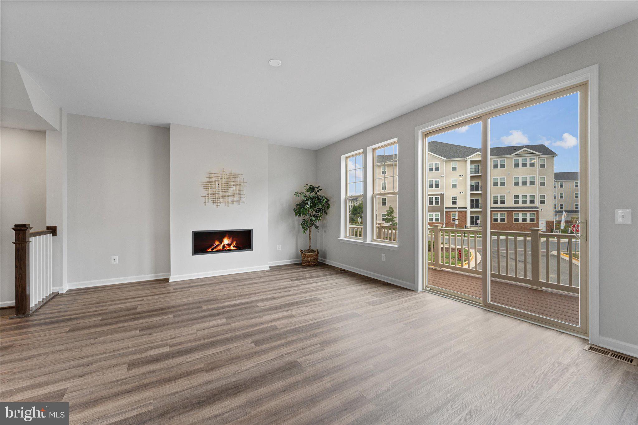 705 Sawback Square Northeast Leesburg, VA 20176 - Photo 10 of 38 an empty room with wooden floor and fireplace