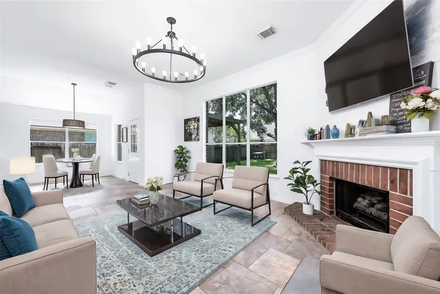a living room with furniture a fireplace a flat screen tv and a large window