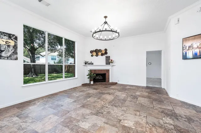 a view of an empty room with a fireplace and a window