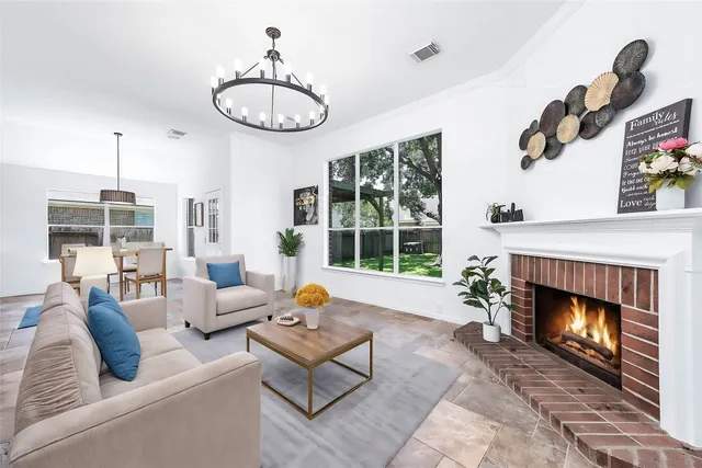 a living room with furniture a fireplace and a large window