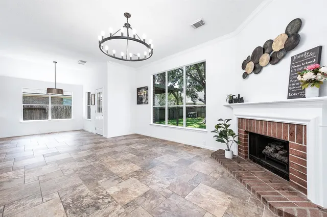 a view of an empty room with a fireplace and a window