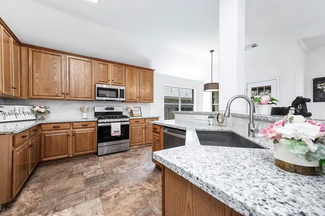 a kitchen with stainless steel appliances granite countertop a sink stove and refrigerator