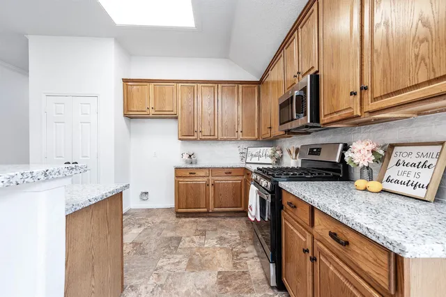 a kitchen with stainless steel appliances granite countertop a stove a sink and a refrigerator