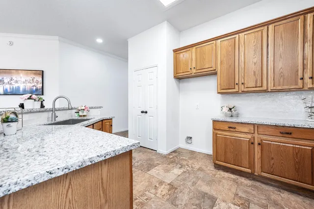 a kitchen with granite countertop a sink dishwasher stove and cabinets
