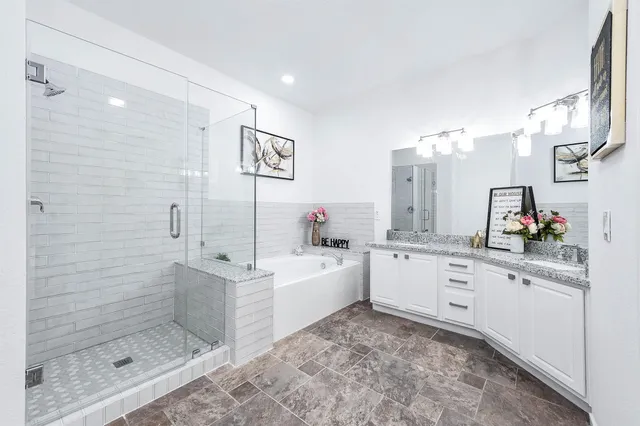a bathroom with a granite countertop sink mirror and bathtub