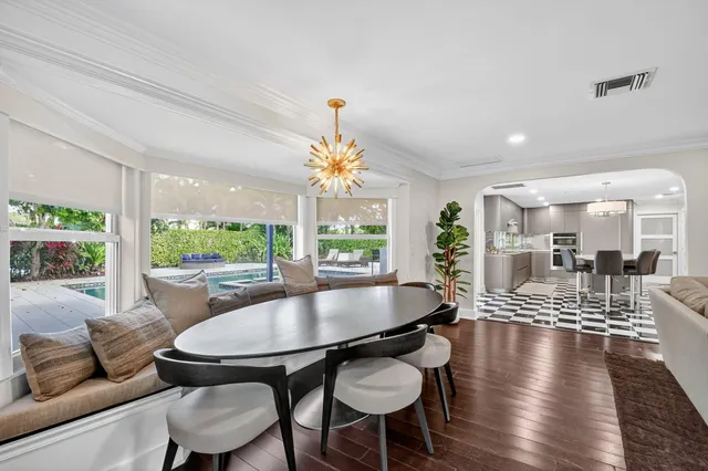 a living room with dining table and a large window