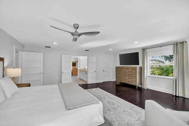a large bedroom with a large bed a chandelier and a large window