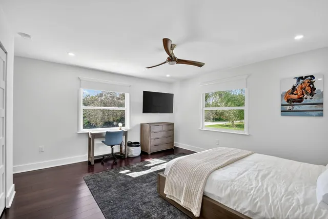 a bedroom with a bed a chair and a chandelier