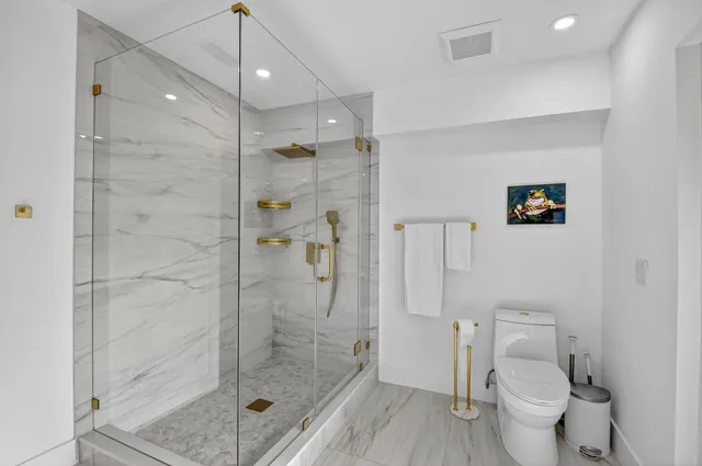 a bathroom with a shower a toilet and a sink