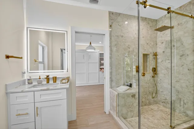 a bathroom with a shower sink and mirror