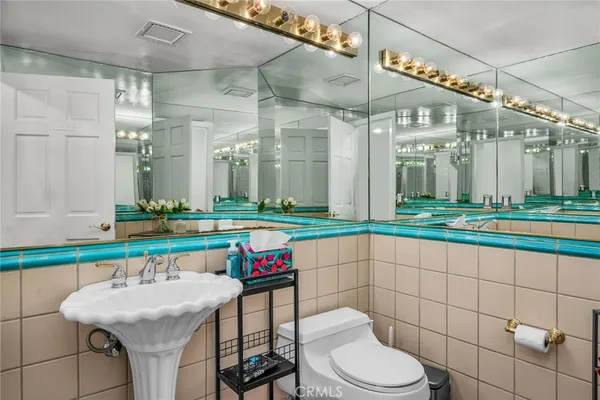 a bathroom with a toilet a sink and a mirror