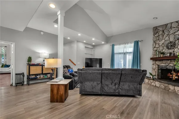 a living room with furniture a fireplace and wooden floor