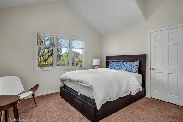 a bed sitting in a bedroom next to a window