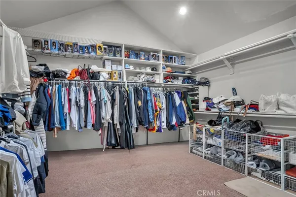 a view of walk in closet with clothes and shoes
