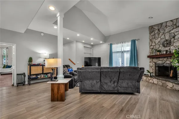 a living room with furniture a fireplace and wooden floor