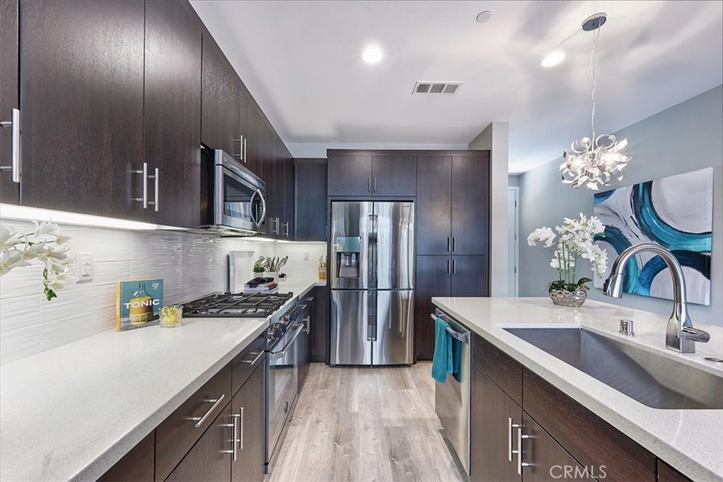 944 Sunlit Lane Costa Mesa, CA 92626 - Photo 11 of 71 a kitchen with stainless steel appliances a sink stove and refrigerator
