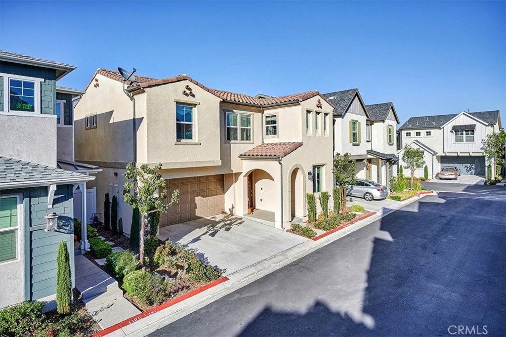 944 Sunlit Lane Costa Mesa, CA 92626 - Photo 2 of 71 a view of a white house with large windows and a table and chairs
