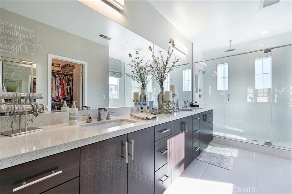 944 Sunlit Lane Costa Mesa, CA 92626 - Photo 35 of 71 a bathroom with a double vanity sink a mirror and shower